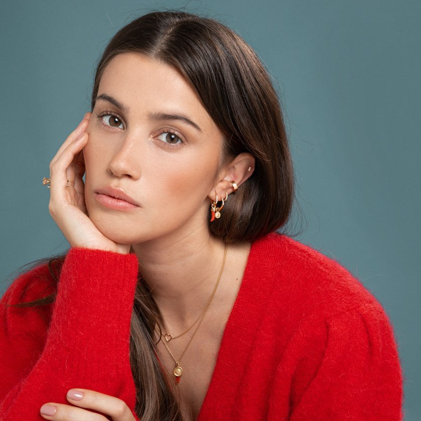 Lilian wearing the Diamond Bar Stud, Gold Ear Cuff, Yellow Gold Diamond Huggy Medium, Diamond Studded Gold Closed Hoop with Angel Pendant, Diamond Studded Closed Hoop with Little Chilli Pendant, the Heart Necklace and the Angel & Little Chilli Necklace by McFarlane Fine Jewellery