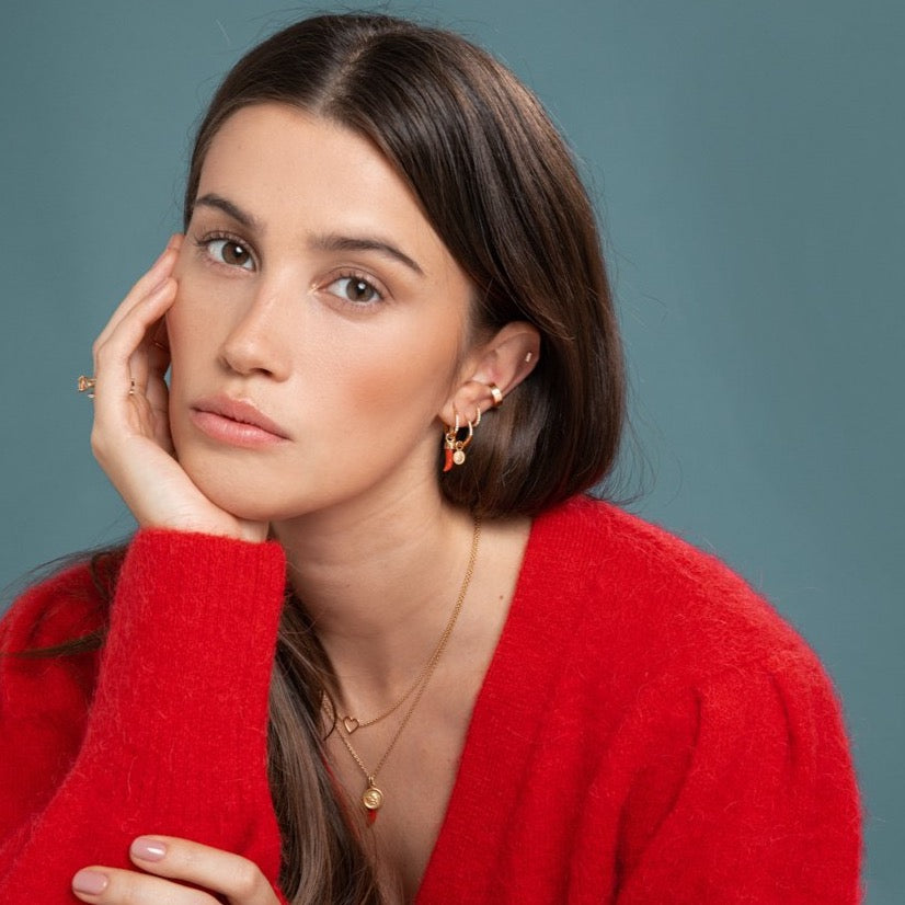 Lilian wearing the Diamond Bar Stud, Gold Ear Cuff, Yellow Gold Diamond Huggy Medium, Diamond Studded Gold Closed Hoop with Angel Pendant, Diamond Studded Closed Hoop with Little Chilli Pendant, the Heart Necklace and the Angel & Little Chilli Necklace by McFarlane Fine Jewellery