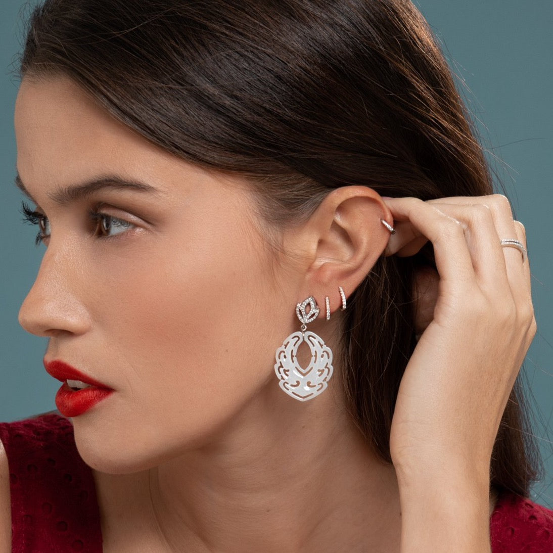 Lilian wearing the White Gold Diamond Huggy Small, a Pair of White Gold Diamond Rings, White Gold Diamond Huggies Medium and the Diamond Lotus & White Jade Earrings by McFarlane Fine Jewellery