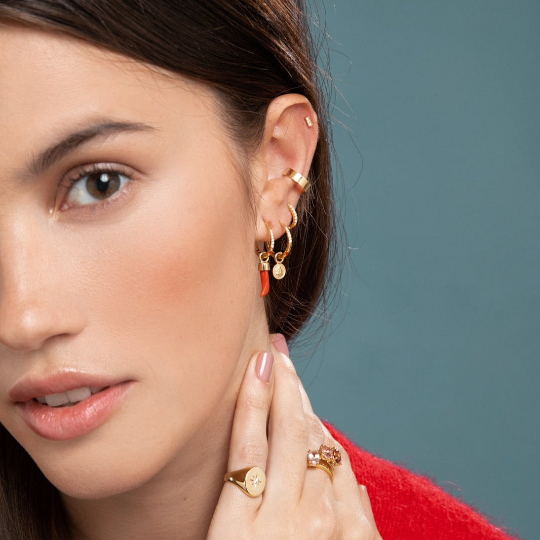 Lilian wearing the Diamond Bar Stud, Gold Ear Cuff, Yellow Gold Diamond Huggy Medium, Diamond Studded Gold Closed Hoop with Angel Pendant, Diamond Studded Closed Hoop with Little Chilli Pendant, the North Star Signet Ring and the stacked Candy Coloured Rings by McFarlane Fine Jewellery