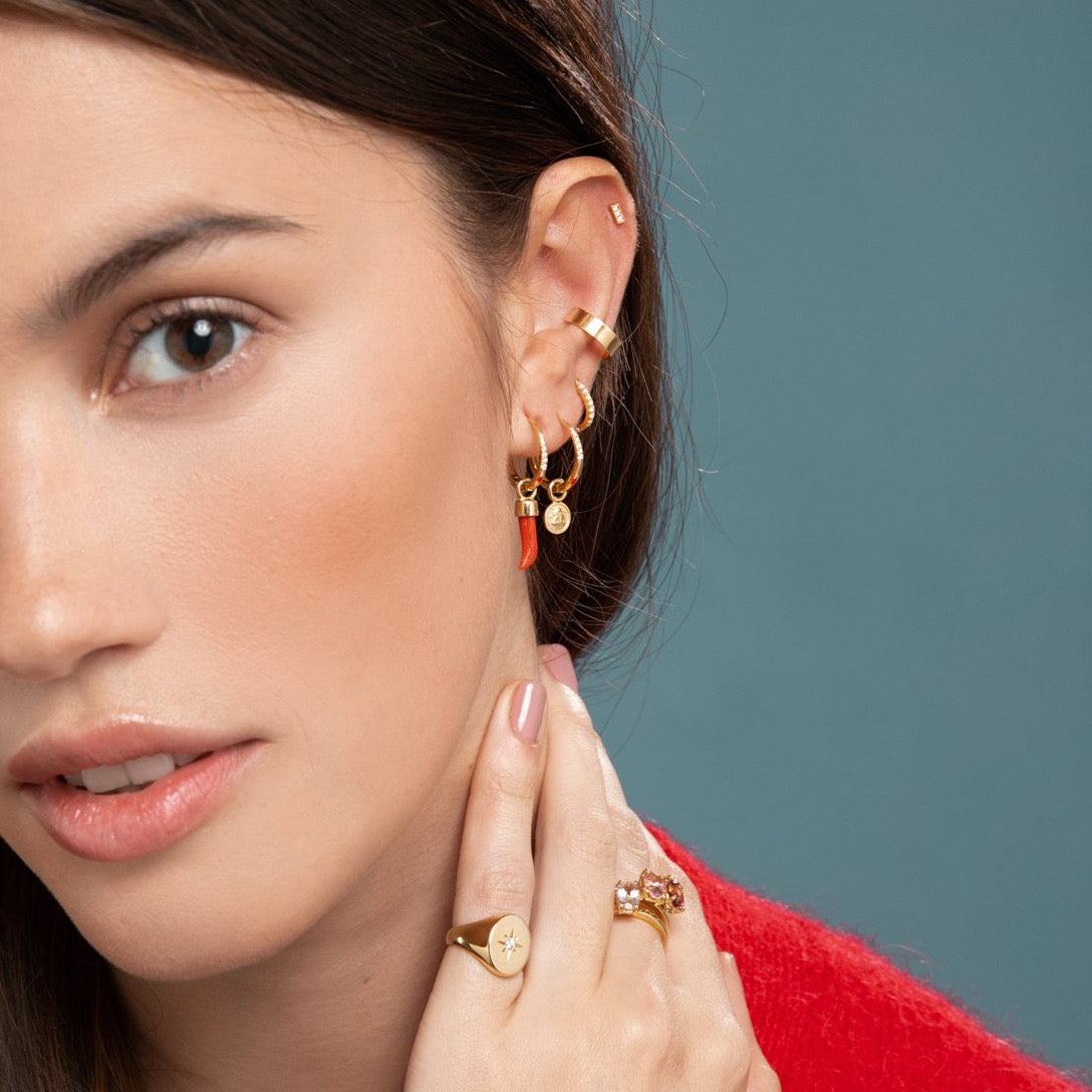 Lilian wearing the Diamond Bar Stud, Gold Ear Cuff, Yellow Gold Diamond Huggy Medium, Diamond Studded Gold Closed Hoop with Angel Pendant, Diamond Studded Closed Hoop with Little Chilli Pendant, the North Star Signet Ring and the stacked Candy Coloured Rings by McFarlane Fine Jewellery